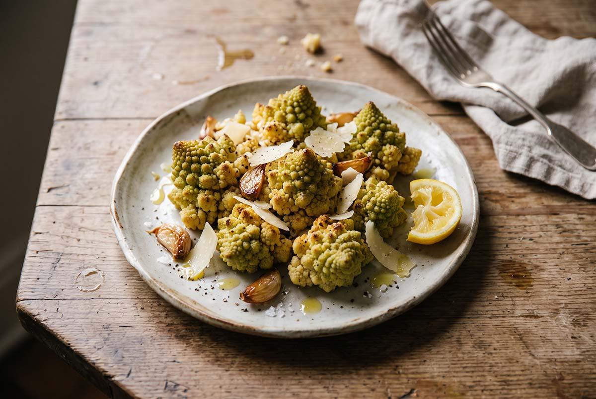 Pieczone romanesco z parmezanem Pieczone różyczki kalafiora romanesco z czosnkiem, parmezanem i oliwą na talerzu
